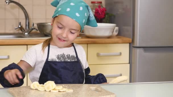 La chica cortó el plátano en una tabla de cortar — Vídeo de stock
