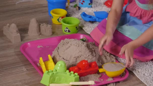 Mão bonito menina loira jogando areia em um estúdio — Vídeo de Stock