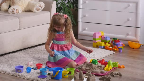 Linda niña rubia jugando a la arena en un estudio — Vídeos de Stock