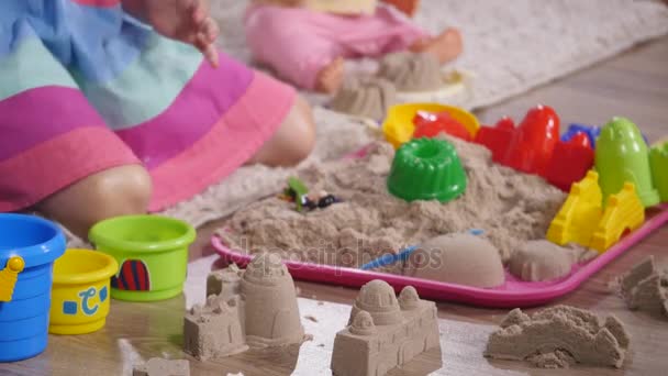 Kézi aranyos szőke kislány játszott homok egy stúdióban. közelről — Stock videók