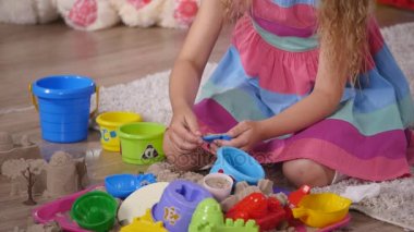 Bir stüdyoda el sevimli küçük sarışın kız iskambil kum. yakın çekim