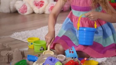 Bir stüdyoda el sevimli küçük sarışın kız iskambil kum. yakın çekim