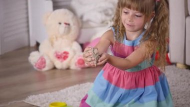 Sevimli küçük sarışın kız iskambil kum bir stüdyoda. ağır çekim