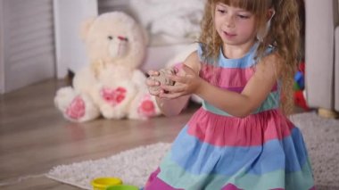 Sevimli küçük sarışın kız iskambil kum bir stüdyoda. ağır çekim