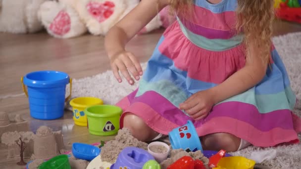 Χέρι χαριτωμένο μικρό ξανθό κορίτσι άμμο παίζει σε ένα στούντιο. κοντινό πλάνο — Αρχείο Βίντεο
