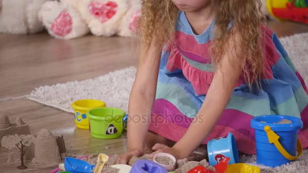 Petite fille blonde mignonne jouant du sable dans un studio. gros plan — Video