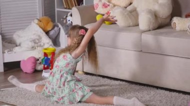 Küçük bir kız, çok güzel genç yetenekli dansçı bale pozlar ve germe egzersizleri evde yerde yok