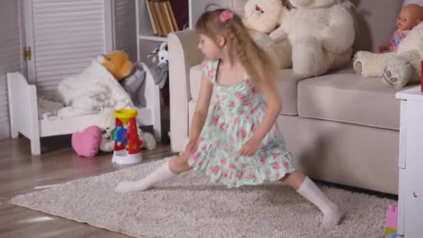 Una bambina, adorabile giovane ballerina di talento fa pose da balletto e esercizi di stretching sul pavimento a casa. — Video Stock