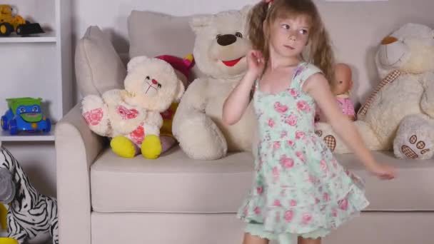 Szczęśliwy blond dziewczyna w sukience zabawy taniec pomieszczeniu w sunny biały pokój w domu lub przedszkole — Wideo stockowe