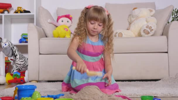 스튜디오에서 귀여운 작은 금발 소녀 재생 모래 — 비디오