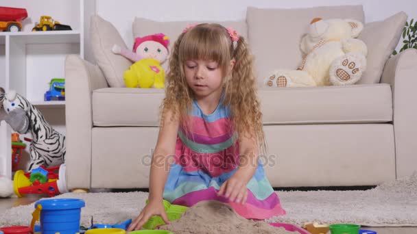 Linda niña rubia jugando a la arena en un estudio — Vídeo de stock