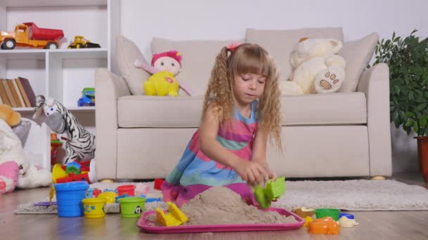 Linda niña rubia jugando a la arena en un estudio — Vídeo de stock