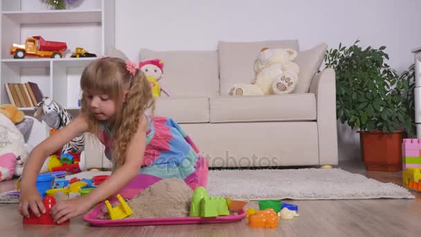 Niedliche kleine blonde Mädchen spielt Sand in einem Studio — Stockvideo