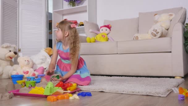 Linda niña rubia jugando a la arena en un estudio — Vídeo de stock