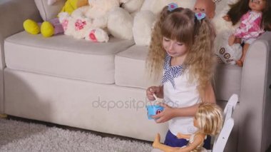 Çocuklar anne-kız Çal bir kız beslemeleri oyuncağın plastik kaşıkla adı gibi oyun oynarken