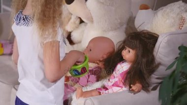 Çocuklar anne-kız Çal bir kız beslemeleri oyuncağın plastik kaşıkla adı gibi oyun oynarken