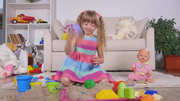 Niedliche kleine blonde Mädchen spielt Sand in einem Studio — Stockvideo