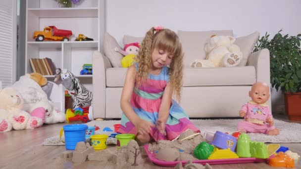 Χαριτωμένο μικρό ξανθό κορίτσι παίζει άμμο σε ένα στούντιο — Αρχείο Βίντεο