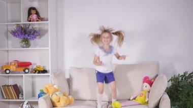 Mutlu çocuk yatağa atlama ve eğleniyor. ağır çekim