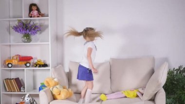 Mutlu çocuk yatağa atlama ve eğleniyor. ağır çekim