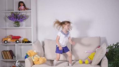 Mutlu çocuk yatağa atlama ve eğleniyor. ağır çekim