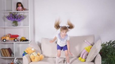 Mutlu çocuk yatağa atlama ve eğleniyor. ağır çekim