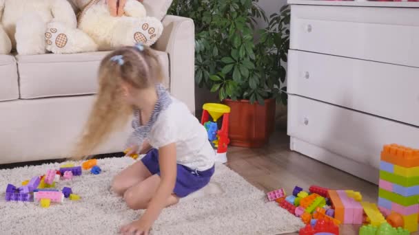 Милая девочка, играющая с игрушкой дома — стоковое видео