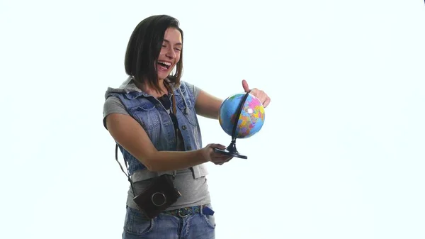 Mulher sorridente bonita apontando para o globo onde quer ir — Fotografia de Stock