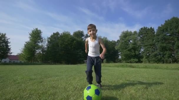 Мальчик играет в футбол на футбольном поле. замедленное движение — стоковое видео