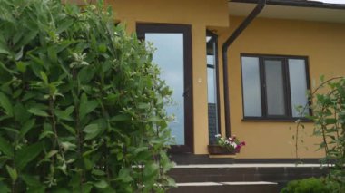 Bir adam telefonla konuşuyor ve evden geliyor