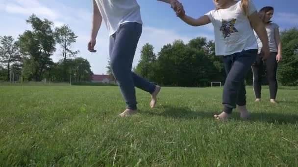 Familia joven feliz con dos niños corriendo en el campo de verano — Vídeo de stock