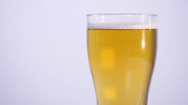 Bardak beyaz arka plan üzerinde boşalma bira. yakın çekim