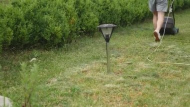 Adam bahçesinde biçme makinesi ile Bahçe çim biçme