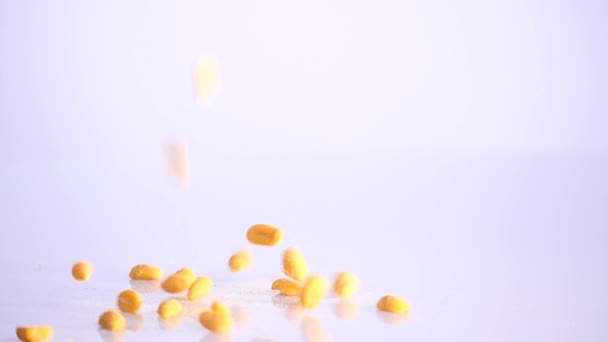 Many peanuts being spilled against on a white background. beer background — Stock Video