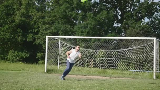 Vader en zoon voetballen op het voetbal op het moment van de dag — Stockvideo