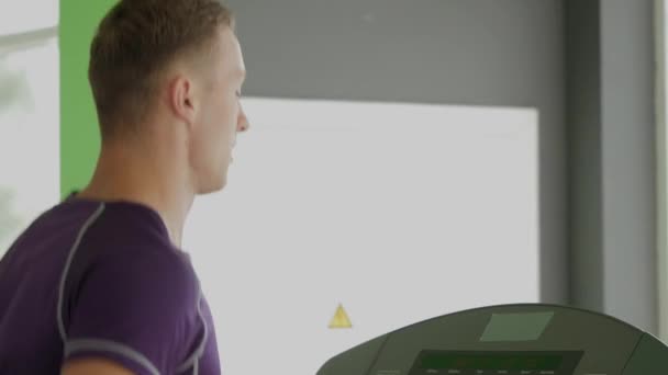 Atlet muda berlari di treadmill di olahraga gym — Stok Video