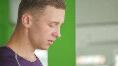 Spor salonunda koşu bandı üzerinde çalışan genç atletik erkek