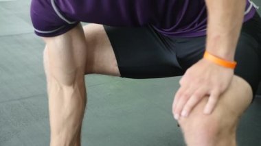 Spor salonunda, o halter kaldırma ve onun pazı çalışma kollarını çalışan adam