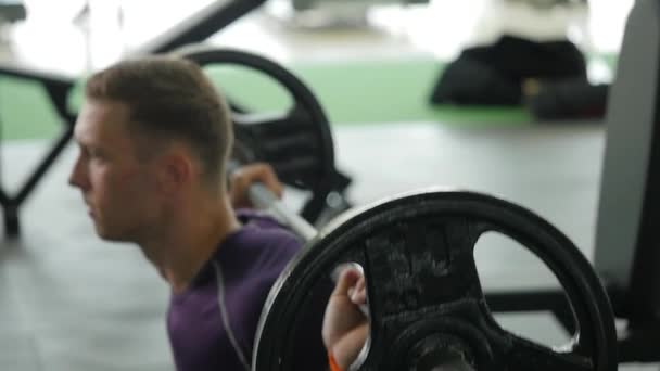 Entrenamiento muscular de hombre con barra en el gimnasio — Vídeos de Stock