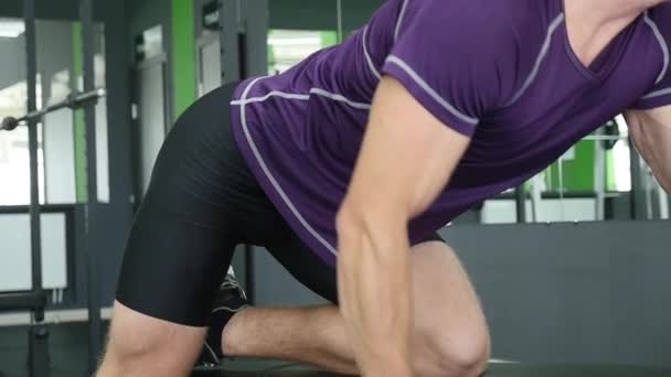 Homme travaillant ses bras au gymnase, levant les haltères et travaillant ses biceps — Video