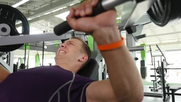 Ung man böjning bröstmuskler på gym maskin — Stockvideo