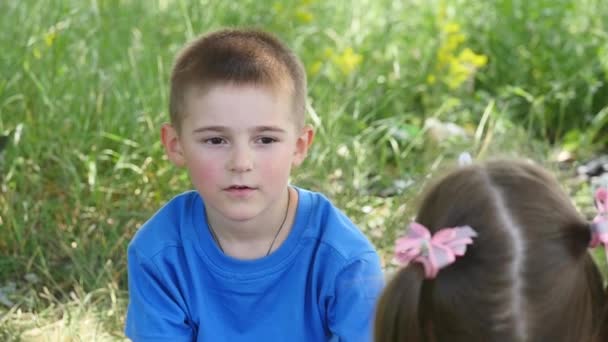 Heureux enfant soufflant des bulles de savon dans le parc de printemps. Mouvement lent — Video