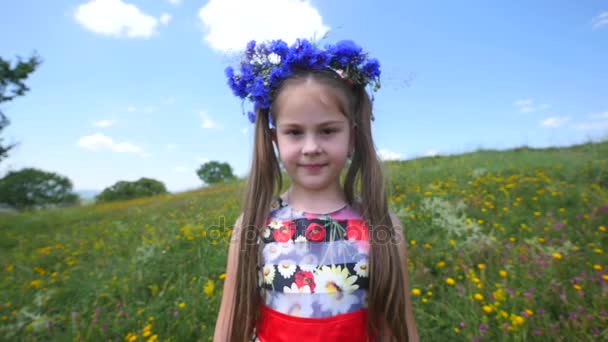 Λίγο χαμογέλασε κορίτσι wildflower φορούν στεφάνι στο κεφάλι της — Αρχείο Βίντεο