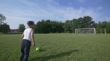 Futbol sahası futbol oynayan çocuk. ağır çekim