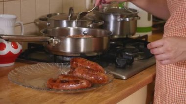 Bir kadın sosis kızartma tavası dan ortaya çıkarır