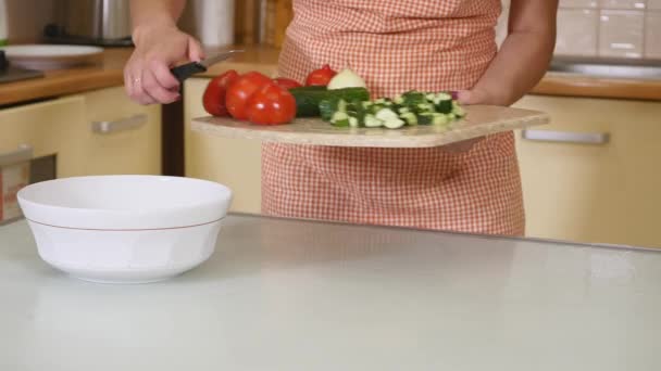 Vrouw handen snijden groenten op houten bord — Stockvideo