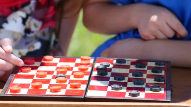 Childrens hands play checkers in the nature — Stock Video