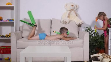 Çocuklar oturma odasında oynarken hayal hakkında bir kumsalda olduklarını