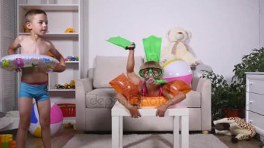 Çocuklar oturma odasında oynarken hayal hakkında bir kumsalda olduklarını