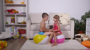 Çocuk iyi eğlenceler oturmak ve büyük lastik şişme top oyun odası atlamak